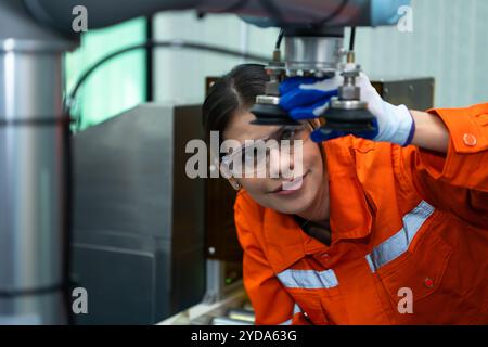 In an electronic parts facility, Female engineers In the plant, inspecting and testing robotic hands used in the production of e Stock Photo