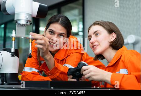 In an electronic parts facility, two female engineers In the plant, inspecting and testing robotic hands used in the production Stock Photo