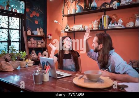 Two young entrepreneurs who own a pottery business. We are discussing the container that the customer wants to be molded. to be Stock Photo