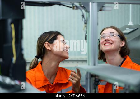Both of woman in an electronic parts factory Using a production line controller and are recommending colleagues to use this tool Stock Photo