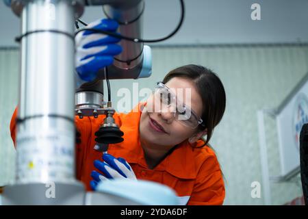 In an electronic parts facility, Female engineers In the plant, inspecting and testing robotic hands used in the production of e Stock Photo
