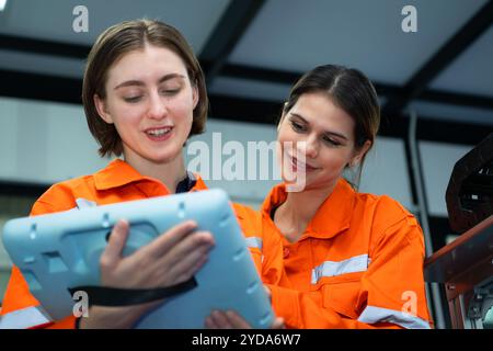 Both of woman in an electronic parts factory Using a production line controller and are recommending colleagues to use this tool Stock Photo