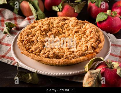 Close-up of an apple crumb pie in a white plate with fresh picked apples Stock Photo