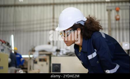 A young female worker is controlling a mechanical robot. Stock Photo