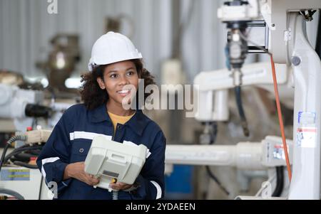 A young female worker is controlling a mechanical robot. Stock Photo