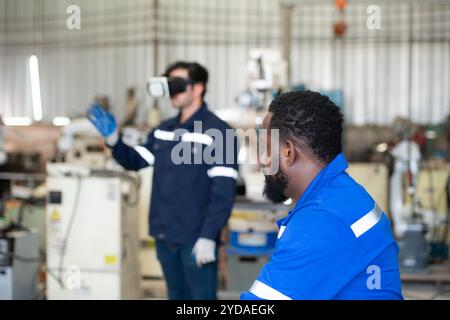 Chief and young male engineer uses a VR machine to operate a welding robot. for precision welding control Stock Photo