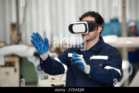 A young male engineer uses a VR machine to operate a welding robot. for precision welding control Stock Photo