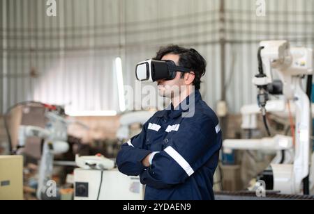 A young male engineer uses a VR machine to operate a welding robot. for precision welding control Stock Photo