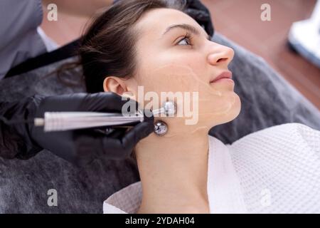 Cosmetology light equipment. Anti age and wrinkle. Microcurrent medicine treatment. Portrait of beautiful woman. Skincare clinic Stock Photo