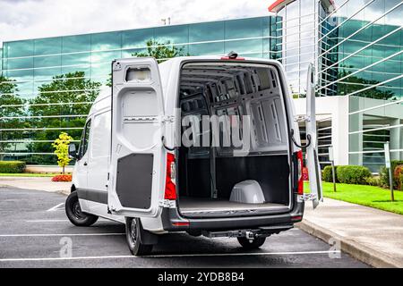 Small Industrial carrier compact white maneuverable and economical cargo mini van make delivery to the customer standing with open back doors on the p Stock Photo