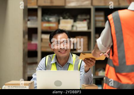 The warehouse manager gave the female assistant a premium. who assisted in the work and planning of the preparation of products Stock Photo