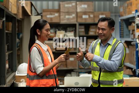 The warehouse manager gave the female assistant a premium. who assisted in the work and planning of the preparation of products Stock Photo