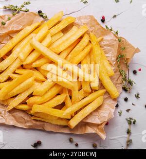 Golden yummy deep french fries on kraft baking sheet paper Stock Photo