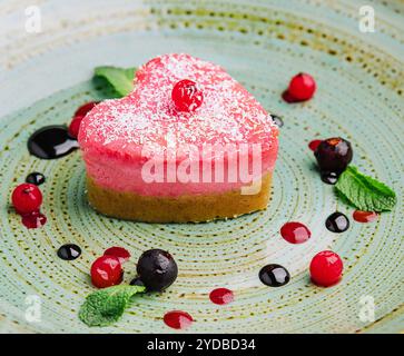 Heart shaped raw vegan red cake with raspberries Stock Photo