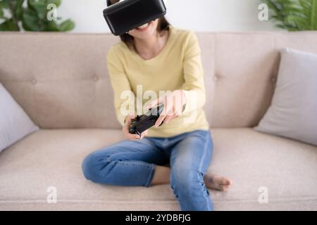 Young woman wearing virtual reality goggles at bedroom, VR innovation technology. Stock Photo