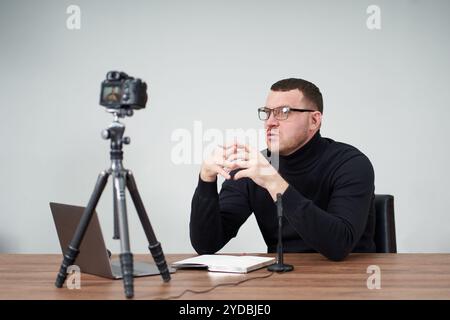 Man filming video blog on camera with tripod for online followers. In social media, Influencer, new technology and internet conc Stock Photo