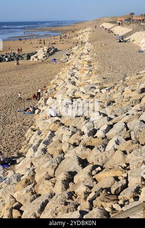 Global warming, rising sea levels and coastal retreat. Rockfilling the coastline in the seaside village of Lacanau-Océan to slow the retreat of the At Stock Photo