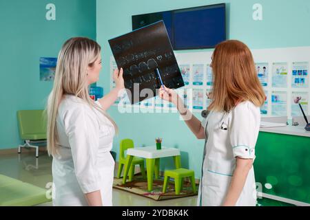 Two doctors looking at x-ray image on screen in clinic Stock Photo