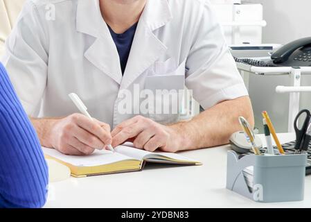 Cropped view of doctor writing in notepad during consulting a patient Stock Photo