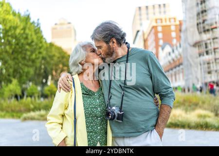 Frontal portrait of a senior couple kissing while visiting a city Stock Photo