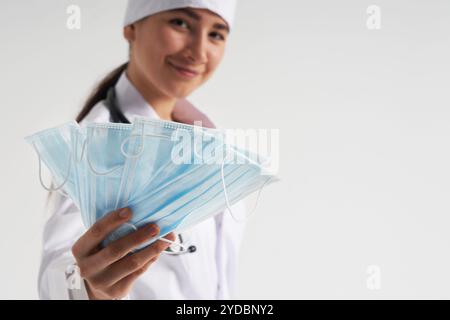 Smiling Doctor or nurse recommend to use protective face mask to protect from virus infection, coronavirus concept Stock Photo