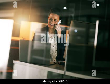 Office, night and woman with phone call by computer for information technology, server or update. Programming, business and developer with tech for Stock Photo