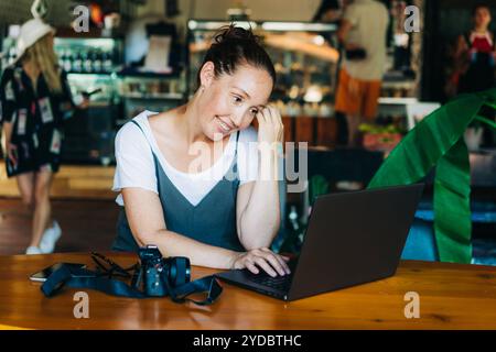 Cute freckled confident woman professional working on laptop in cafe. Stock Photo