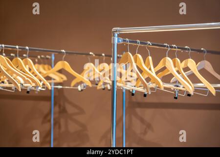 Wooden hangers on coat rack with no clothes in cloakroom Stock Photo