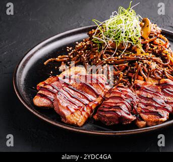 Soba beef and vegetables, Buckwheat noodles on a dark stone background Stock Photo