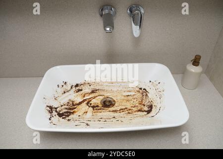 Dirty white sink in the bathroom after a clogged pipe. Ceramic washbasin in dirty rust Stock Photo