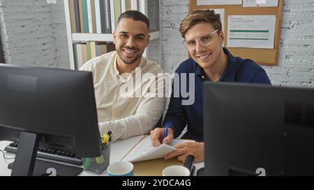 Handsome men working together at modern office with computers and documents, smiling confidently Stock Photo