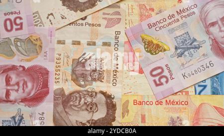 Mexican pesos banknotes of various denominations spread out in a detailed and colorful layout, showcasing currency designs from banco de méxico. Stock Photo