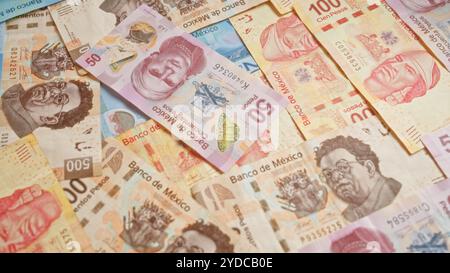 Colorful mexican banknotes of various denominations scattered in a pile, displaying vibrant designs and prominent figures representing currency in mex Stock Photo