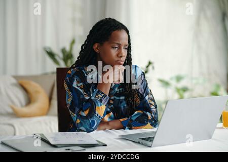 Contemplating Work at Desk with Laptop and Documents Stock Photo