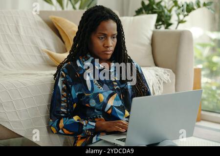 Working on Laptop While Sitting on Floor in Living Room Stock Photo