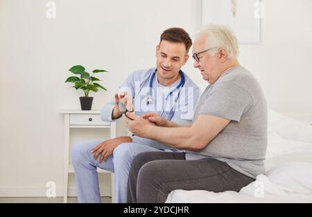 Young doctor and his senior patient are using a healthcare app on the mobile phone Stock Photo