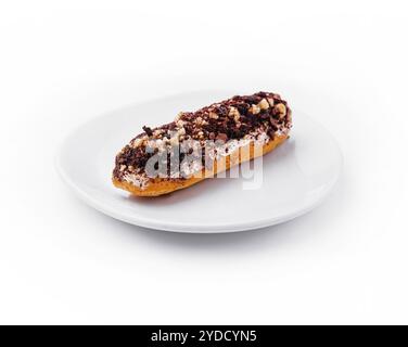 Eclair with chocolate and nuts on a white plate Stock Photo