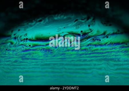 Bright rainbow reflection of liquid in macro, white colors, surrealistic background, fantastic smooth movement Stock Photo