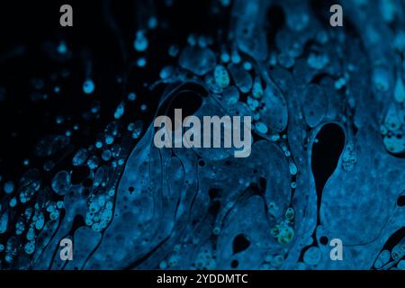 Bright blue dots on black background, oil stains movement, bright chemistry, surreal background, blue sky colour Stock Photo