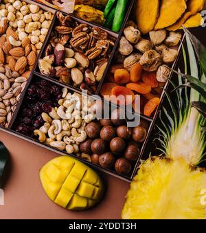 Assorted nuts and dried tropical fruits in a wooden box Stock Photo