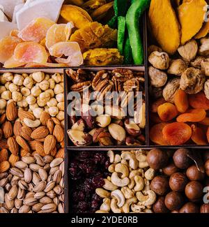 Assorted nuts and dried tropical fruits in a wooden box Stock Photo