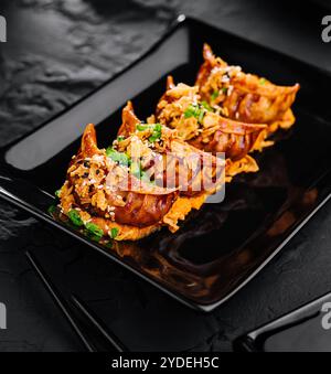 Fried dumplings Gyoza on black plate Stock Photo