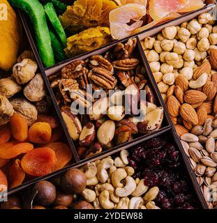 Assorted nuts and dried tropical fruits in a wooden box Stock Photo