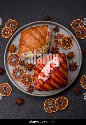 Crispy sweet red croissant with pistachio, raspberry and strawberry Stock Photo