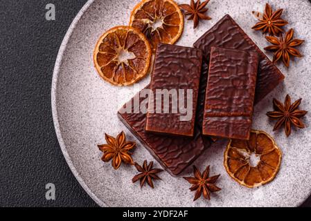 Rectangular chocolate candies with mousse and waffles on a dark concrete background Stock Photo