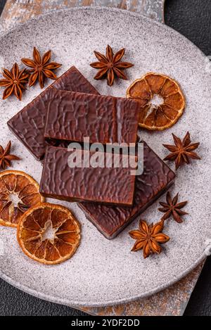 Rectangular chocolate candies with mousse and waffles on a dark concrete background Stock Photo