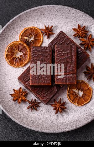 Rectangular chocolate candies with mousse and waffles on a dark concrete background Stock Photo