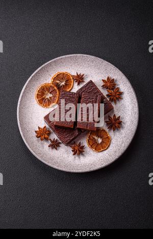 Rectangular chocolate candies with mousse and waffles on a dark concrete background Stock Photo