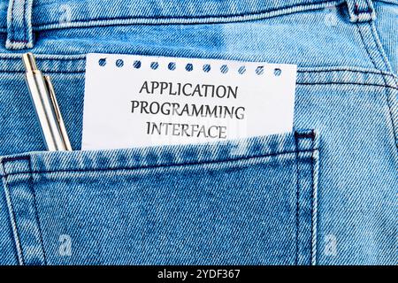 The concept of technology and development. Phrase, words, text APPLICATION PROGRAMMING API It's written on a piece of paper in my jeans pocket. Stock Photo