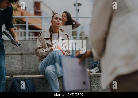 High school students collaborating outdoors with professor assistance Stock Photo
